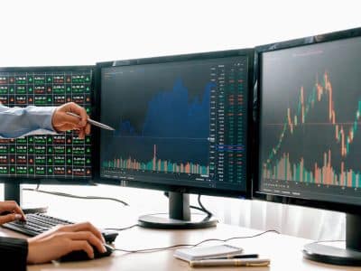 Multi-monitor day trading setup with charts and order screens