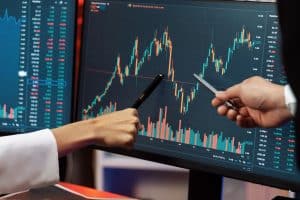 Two Traders pointing at a SPX Candlestick Chart